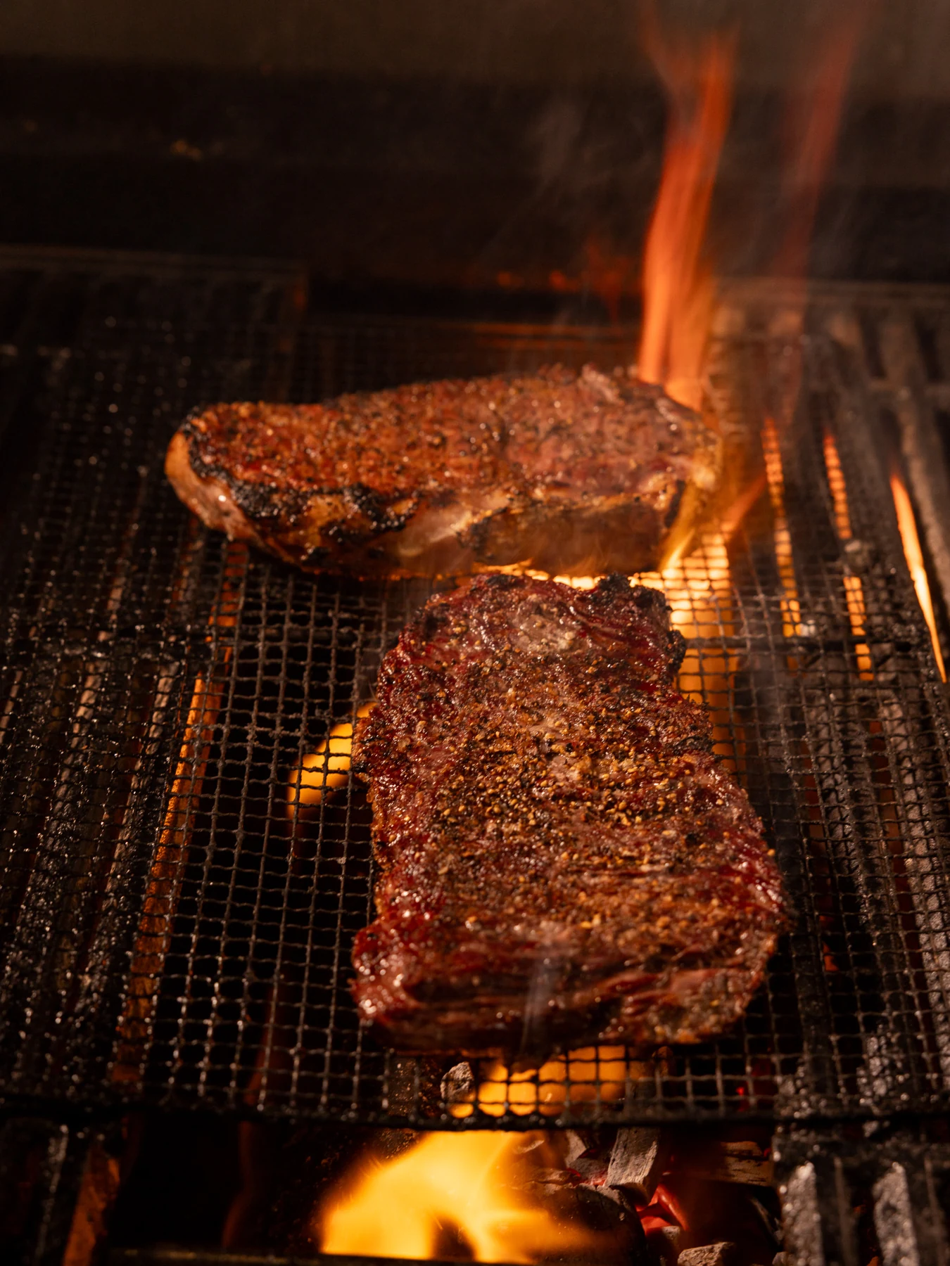 Steaks cooking over an open flame